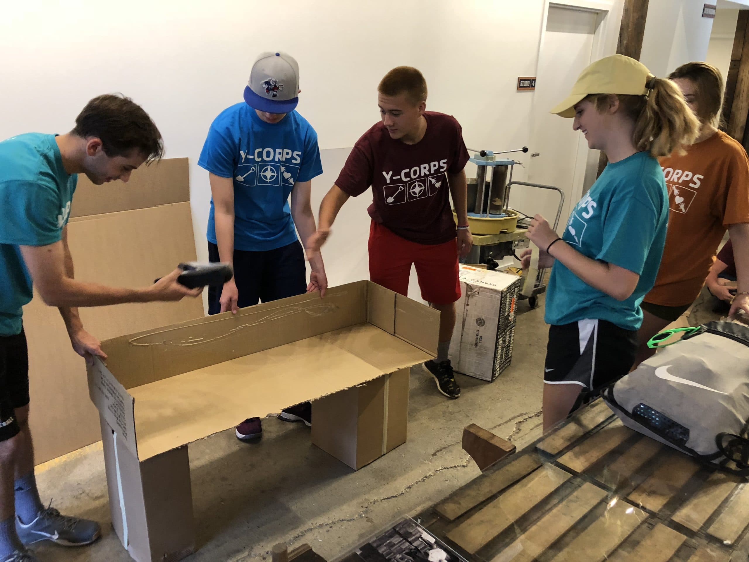 Will Byerman, Everett Parker-Noblitt, Davis Zimmerman, and Darby Greenwell create a cardboard bench for the 20th Street Pop-Up Block.