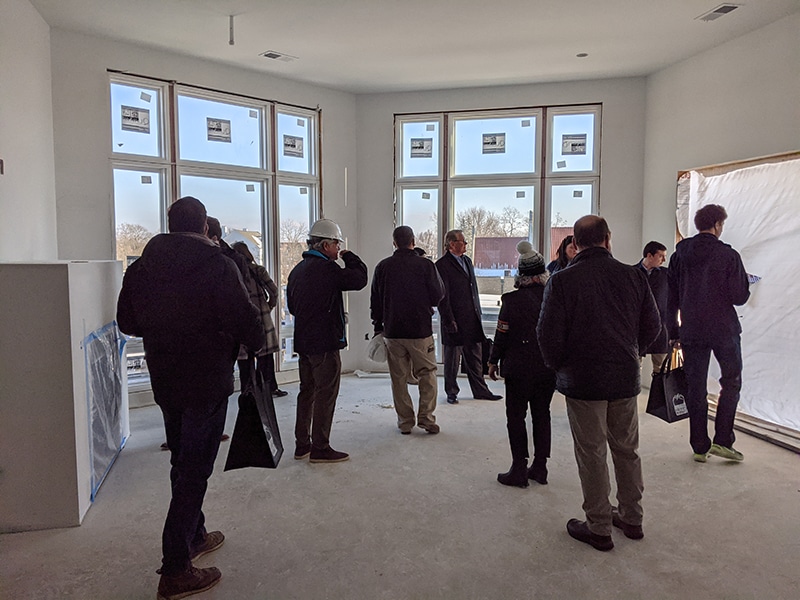 Tour group gathers in front of windoe at One Highland condo.