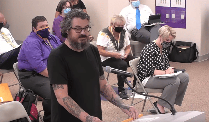 Parent speaks at podium during school board meeting