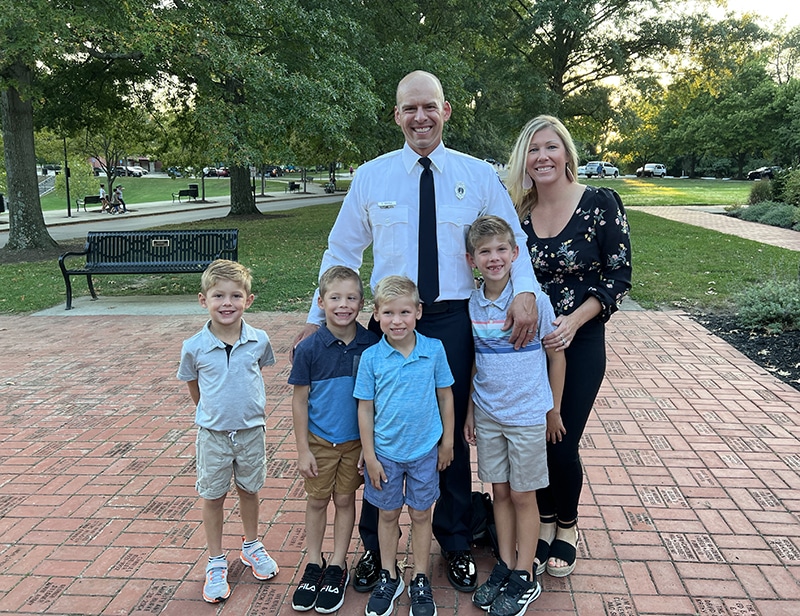 A family poses for a photo with father, mother and four little boys