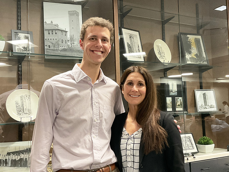 Man and woman stand in front of city trophy case.
