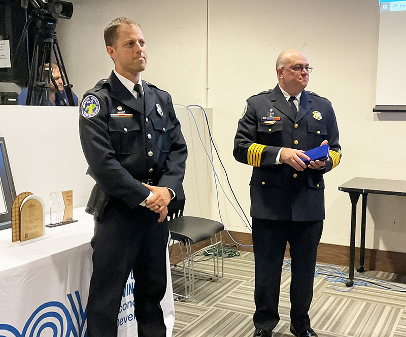 Two men in police uniforms stand at a podium.