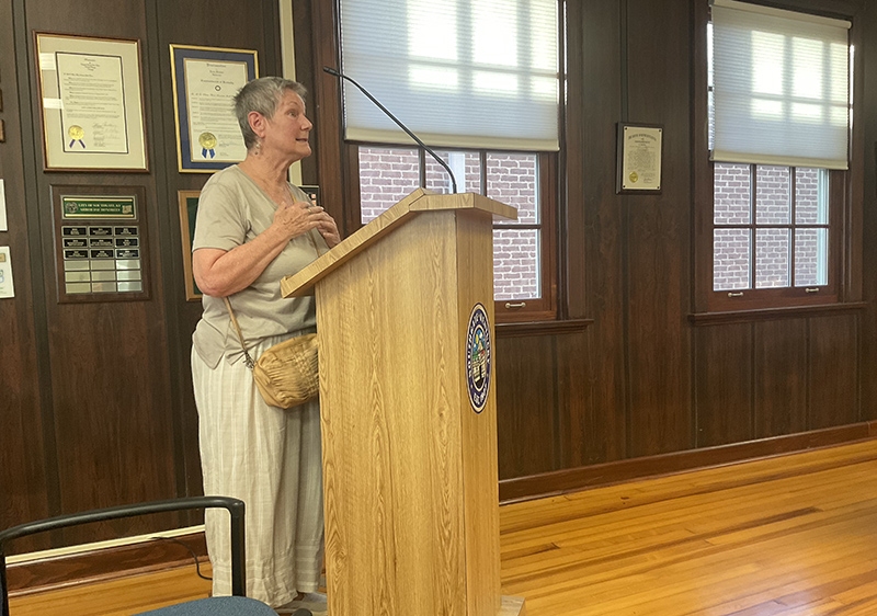 Woman stands at a podium.