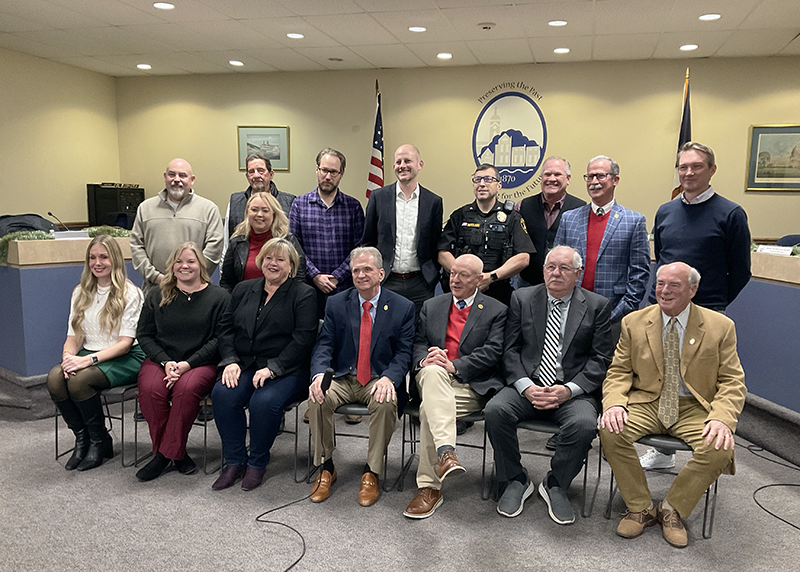 Two rows of people, back row standing, front row seated pose for a photo.