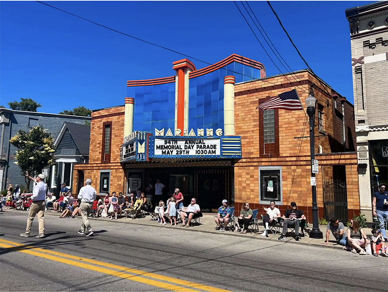 An old theater with facade on a busy street.
